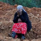 Esther Kinyanjui sits near the search and rescue operations for people feared trapped by...