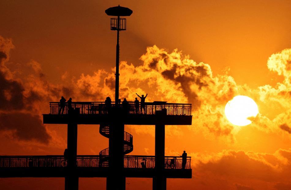 Revellers celebrate the sunrise during the July Morning festival at the pier of Burgas, on the...