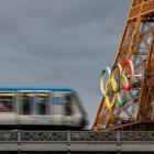 An elevated metro train passes over the Pont de Bir-Hakeim bridge, as the Eiffel Tower displays...