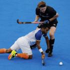 Sumit Sumit, of India, dives in to steal the ball from Black Stick Blair Tarrant during a men’s...