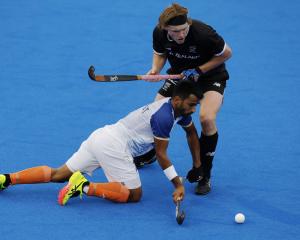 Sumit Sumit, of India, dives in to steal the ball from Black Stick Blair Tarrant during a men’s...