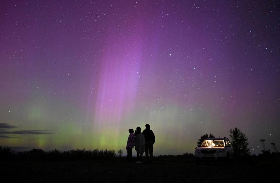 The Northern Lights (aurora borealis) illuminate the sky as people gather to watch the annual...