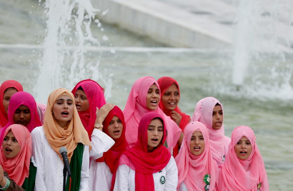 Attendees perform Pakistan’s national anthem during Independence Day celebrations, at the...