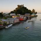 The morning's first rays of sunlight hit the island community of Serua Village, Fiji, in this...