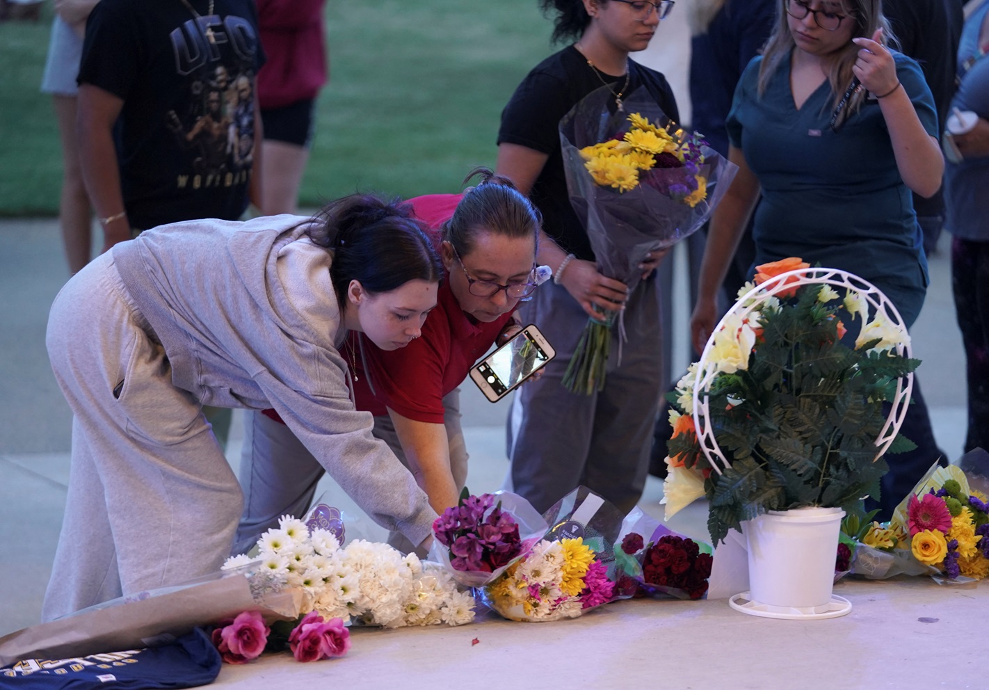 People lay flowers while attending a vigil in Winder, Georgia following the shooting at Apalachee...