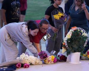 People lay flowers while attending a vigil in Winder, Georgia following the shooting at Apalachee...