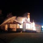 Firefighters douse the flames coming from the homestead at Hinds on Sunday. PHOTO: SUPPLIED