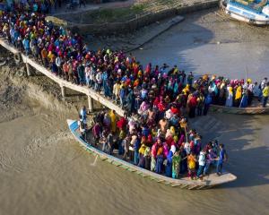 Crowds of climate migrant workers cross the Poshur river in Bangladesh to work in an export...