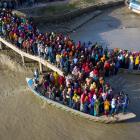 Crowds of climate migrant workers cross the Poshur river in Bangladesh to work in an export...