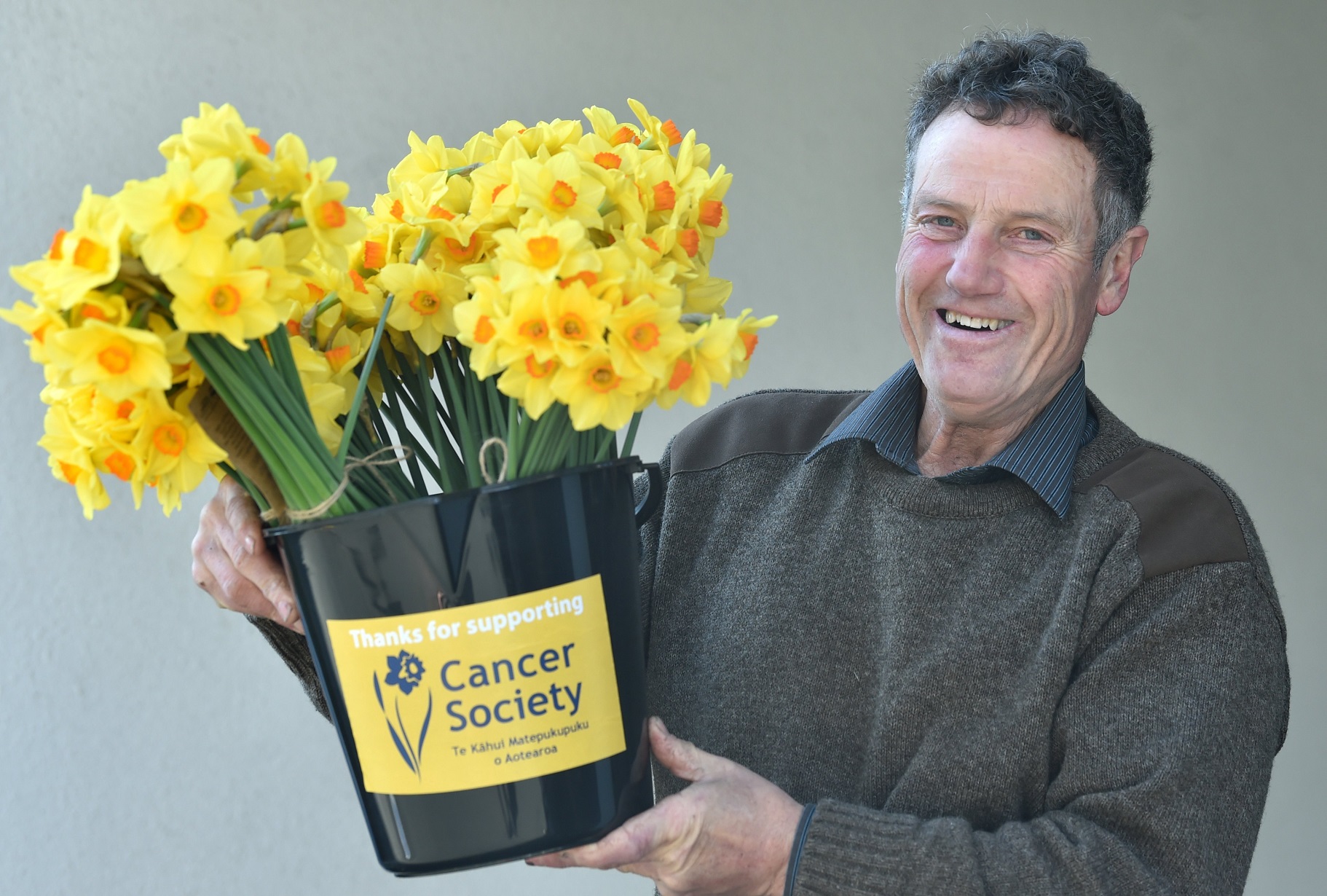 Gore resident David Christie holds a bucket of flowers during Daffodil Day in Dunedin yesterday....