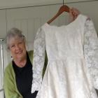 Ange Gibbs holds a wedding gown worn by Coralie Heads on her wedding day in 1965. PHOTO: SUPPLIED