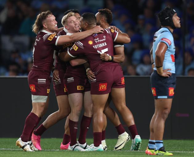 Queensland celebrate a try on a dismal night for Blues fans in Sydney. Photo: Getty Images