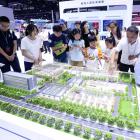 Visitors view a smart park model of State Grid Tianjin Electric Power at the 26th China Beijing...