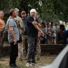 People stand near the Poltava Military Institute of Communications, the site of a Russian missile...