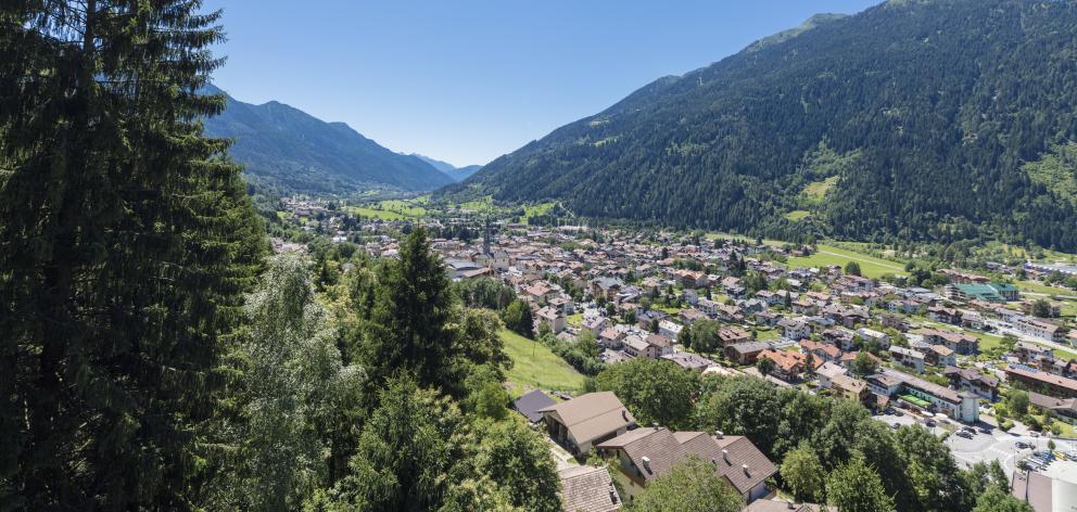 Blue sky and woods frame the alpine village of Pinzolo.