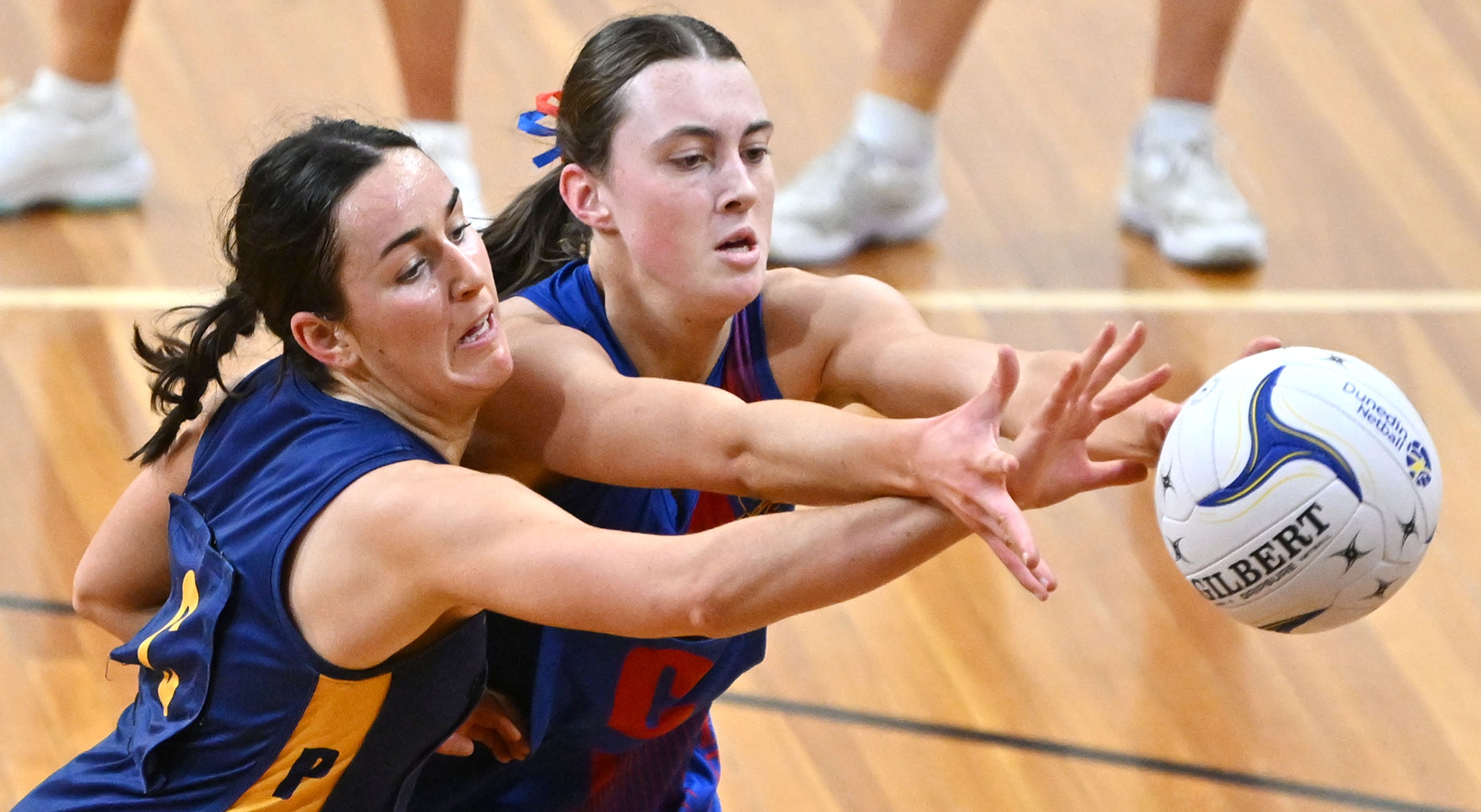 Rival midcourters Millie Hassall (left, Physed A) and Olivia Mavor (University-Albion A) reach...