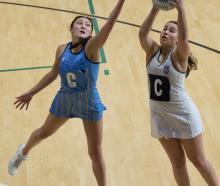 Milla Cashmore of Columba secures a pass despite the attention of Kyla Ashton  during the Otago...