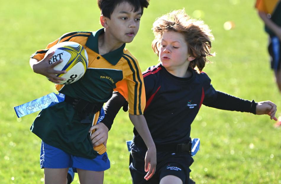 Marcel Rewha, 9, of Pine Hill School, tries to evade Grant’s Braes School defender Josef Lippross...