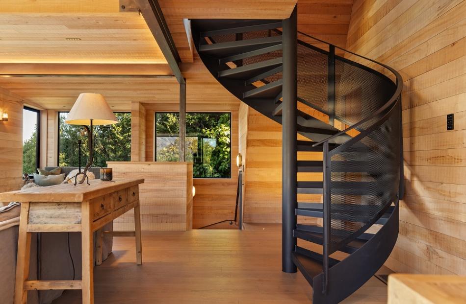 The black spiral staircase leads to bedrooms on the top level.