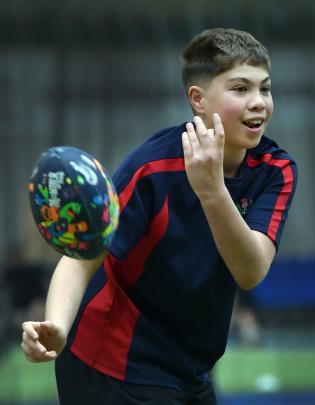 Tane Christian, 11, passes a rugby ball. 