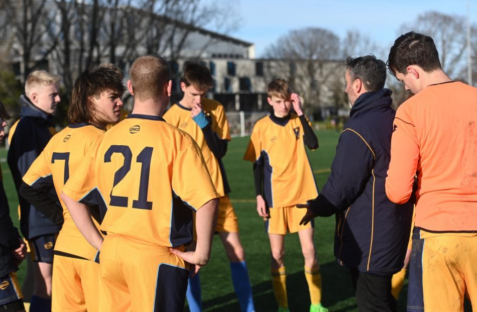 Taieri football coach Dave Bainbridge talks to his players during a break in play.