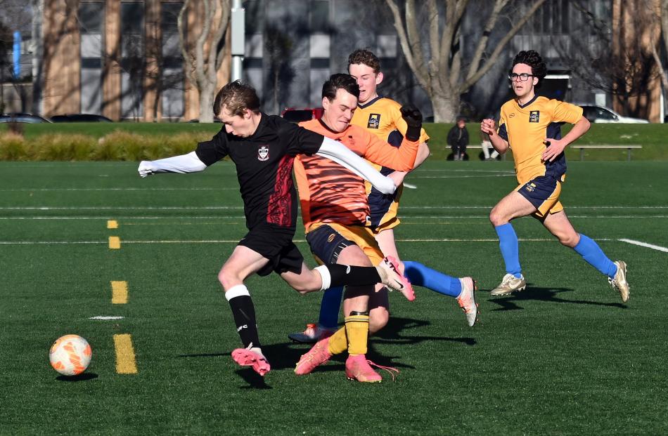 Logan Park footballer Sam Heron gets past Taieri goalkeeper Murray Boyne and defenders Jack...