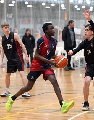 Trinity Catholic College basketballer Fola Shittu powers to the hoop against Logan Park.